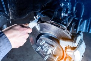 Technician inspecting brake pads and brake disc condition