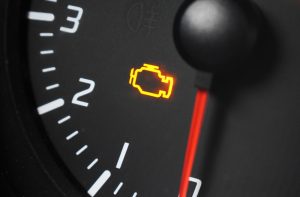 Amber engine management light illuminated on a car dashboard